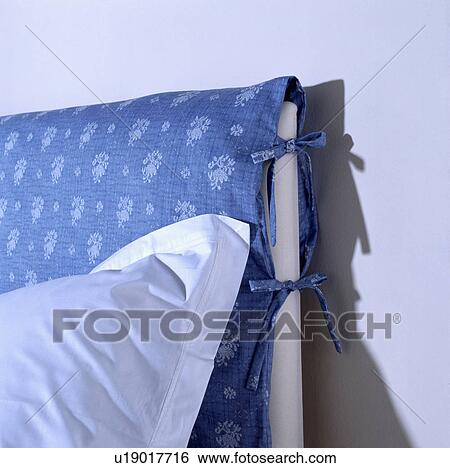 Close-up of white cotton pillow on blue padded bedhead with ribbon ties View Large Photo Image Stock Photograph - Close-up of white cotton pillow on blue padded bedhead with ribbon ties. Fotosearch
