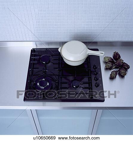 Stock Photo - Close-up of white pan on black gas hob&#13; &#10; &#13; &#10; &#13; &#10; &#13; &#10; &#13; &#10; &#13; &#10;. Fotosearch
