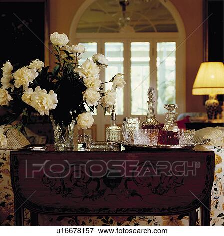 Close-up of white roses in vase on antique table with glass decanters View Large Photo Image Stock Photo - Close-up of white roses in vase on antique table with glass decanters. Fotosearch