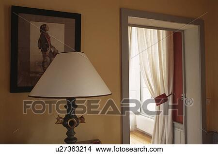 Close-up up lamp with cream shade beside doorway with view of white curtains View Large Photo Image Picture - Close-up up lamp with cream shade beside doorway with view of white curtains . Fotosearch