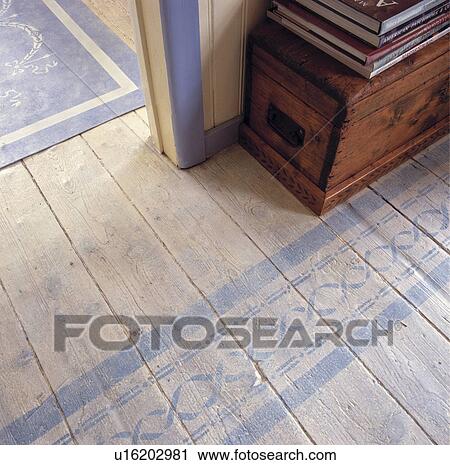 Stock Image - Closeup of stencilled floor design on limed floor boards.. Fotosearch