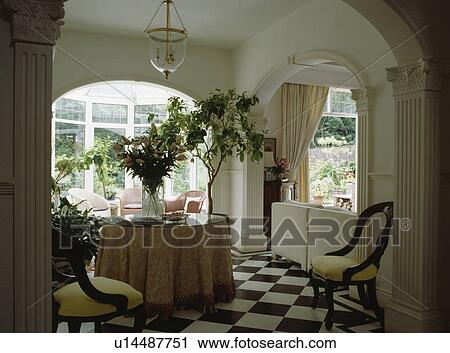 Cloth on circular table in hall with houseplants and black and white checked flooring View Large Photo Image Stock Image - Cloth on circular table in hall with houseplants and black and white checked flooring. Fotosearch