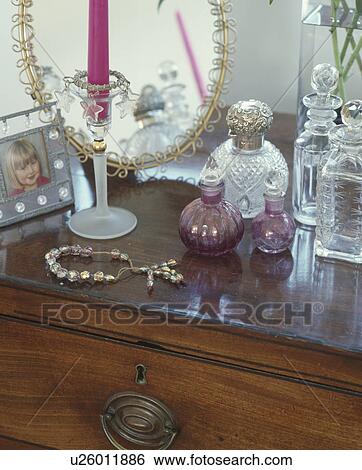 Collection of antique glass perfume bottles and glass necklace on Victorian chest-of-drawers View Large Photo Image Stock Photograph - Collection of antique glass perfume bottles and glass necklace on Victorian chest-of-drawers. Fotosearch