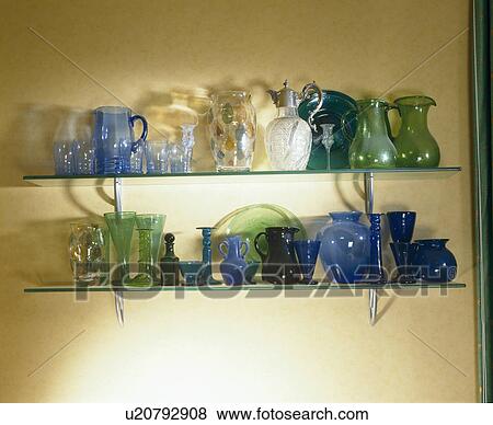 Collection of blue and green glass jugs and vases on glass shelves View Large Photo Image Stock Photo - Collection of blue and green glass jugs and vases on glass shelves. Fotosearch