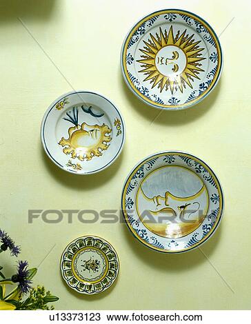 Stock Image - Collection of ceramic sun and moon patterned plates on the wall. Fotosearch