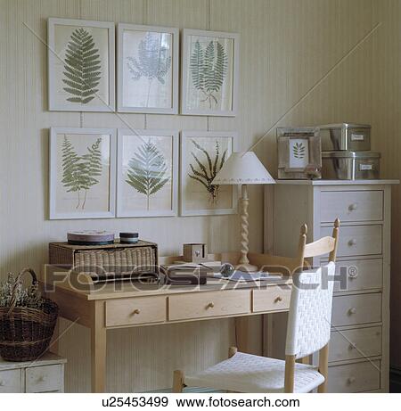 Collection of framed fern print above contemporary desk and chair in neutral study View Large Photo Image Stock Photo - Collection of framed fern print above contemporary desk and chair in neutral study. Fotosearch