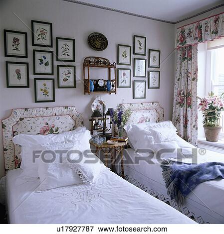 Collection of framed horticultural prints above twin beds with upholstered floral headboards and white bedlinen View Large Photo Image Stock Photo - Collection of framed horticultural prints above twin beds with upholstered floral headboards and white bedlinen. Fotosearch