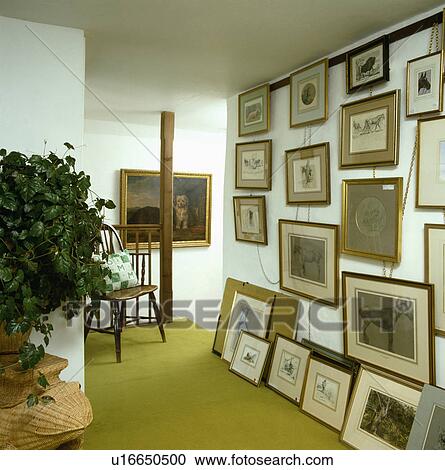 Collection of pictures on landing wall and floor with green carpet and houseplant View Large Photo Image Stock Image - Collection of pictures on landing wall and floor with green carpet and houseplant. Fotosearch