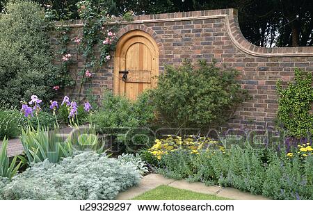 Stock Photo - Colourful perennials in flower borders in large walled country garden in summer. Fotosearch