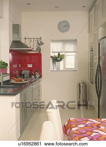 Compact modern kitchen with brushed steel units and red glass panelling View Large Photo Image Stock Image - Compact modern kitchen with brushed steel units and red glass panelling. Fotosearch