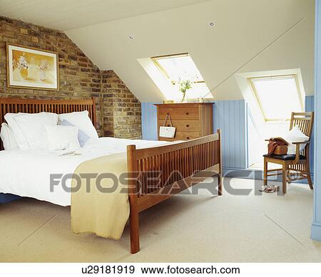 Contemporary blue and white bedroom with exposed brickwork under the eaves of an attic conversion View Large Photo Image Stock Photo - Contemporary blue and white bedroom with exposed brickwork under the eaves of an attic conversion. Fotosearch
