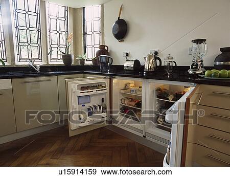 Stock Photo - Contemporary cream kitchen with parquet wood floor, leaded windows and open double low level fridge. Fotosearch