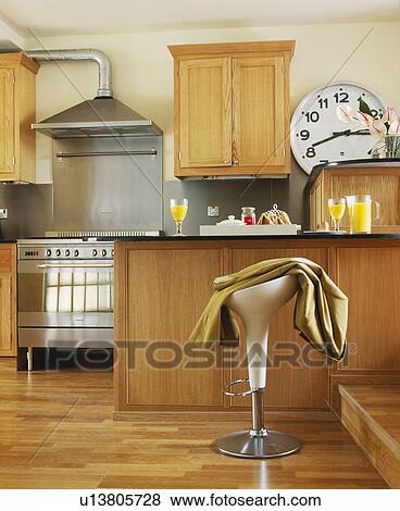 Contemporary wooden kitchen with stainless steel stove and extractor, breakfast bar and stool. View Large Photo Image Stock Photo - Contemporary wooden kitchen with stainless steel stove and extractor, breakfast bar and stool.. Fotosearch