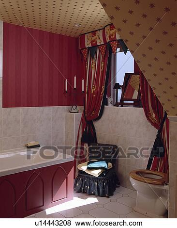 Contrasting cream star patterned and pink striped wallpaper in attic bathroom with marble wall tiles and patterned curtains View Large Photo Image Stock Photo - Contrasting cream star patterned and pink striped wallpaper in attic bathroom with marble wall tiles and patterned curtains. Fotosearch