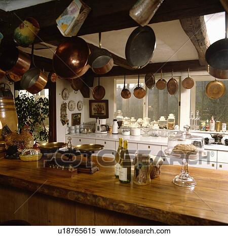 Copper pans above island unit with scales on wooden worktop in cottage kitchen View Large Photo Image Stock Photography - Copper pans above island unit with scales on wooden worktop in cottage kitchen. Fotosearch
