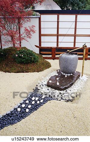 Stock Photo - Corner of a japanese style garden with water and stream of pebbles.. Fotosearch