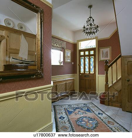 Stock Photo - Cream anaglypta wallpaper below dado-rail in hall with terracotta wallpaper and patterned rug on white tiled floor. Fotosearch