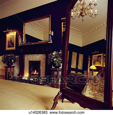 Cream carpet and cheval mirror in black bedroom with large gilt mirror above fireplace with lighted fire View Large Photo Image Stock Image - Cream carpet and cheval mirror in black bedroom with large gilt mirror above fireplace with lighted fire. Fotosearch