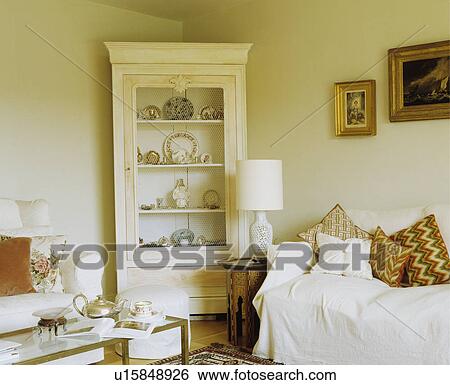 Cream corner bookcase in cream cottage living room View Large Photo Image Stock Photograph - Cream corner bookcase in cream cottage living room. Fotosearch