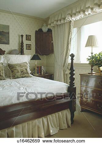 Stock Photo - Cream curtains with pelmet in small country bedroom. Fotosearch