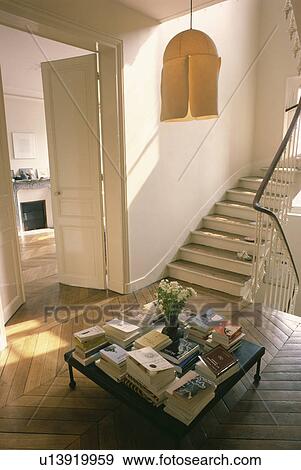 Cream lampshade above books on table on landing with parquet floor View Large Photo Image Stock Photo - Cream lampshade above books on table on landing with parquet floor. Fotosearch