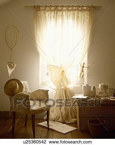 Cream loosecover on chair in front of window with cream voile curtain View Large Photo Image Stock Image - Cream loosecover on chair in front of window with cream voile curtain. Fotosearch