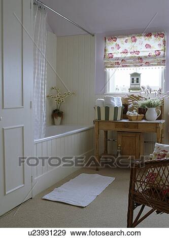 Stock Photo - Cream panelling and rose patterned blind in traditional pastel mauve bathroom with cream carpet. Fotosearch