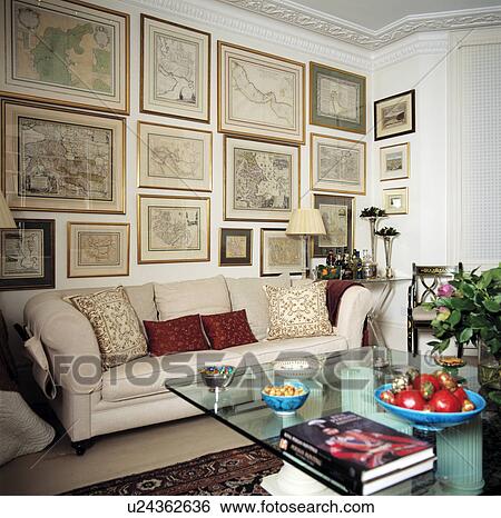 Stock Photograph - Cream sofa below pictures in traditional living room . Fotosearch