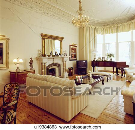 Stock Image - Cream sofa in traditional living room. Fotosearch