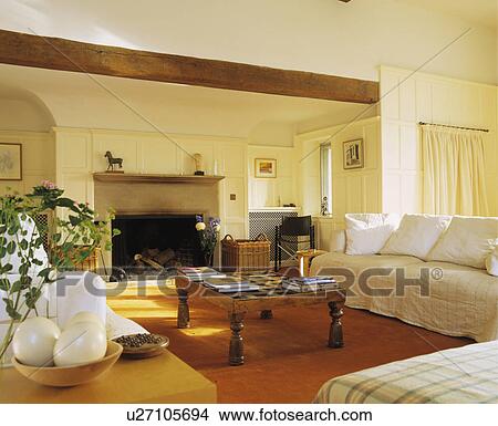 Picture - Cream sofas and wooden coffee table in large cream living room. Fotosearch