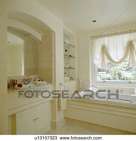 Cream voile festoon blind above bath in modern bathroom with mirror above recessed basin View Large Photo Image Stock Image - Cream voile festoon blind above bath in modern bathroom with mirror above recessed basin. Fotosearch