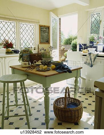 Crockery and lemons on pastel green table with matching stool in country kitchen with basket on black+white flooring View Large Photo Image Stock Image - Crockery and lemons on pastel green table with matching stool in country kitchen with basket on black+white flooring. Fotosearch