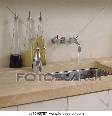 Stock Photo - Details of kitchen counter with stainless steel sink and taps.. Fotosearch