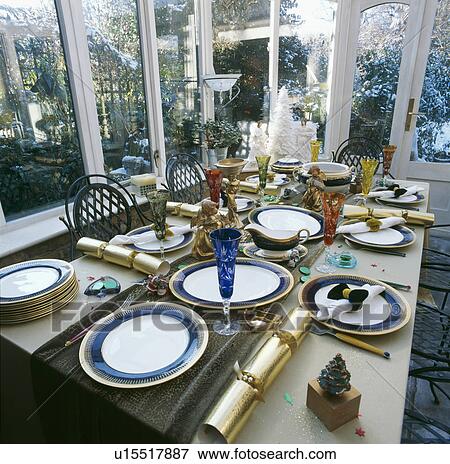 Stock Photo - Dining table decorated for Christmas with colourful wineglasses and gold crackers. Fotosearch