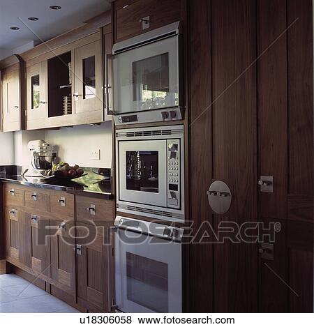 Double oven and microwave in fitted wood cupboards in modern kitchen View Large Photo Image Stock Photo - Double oven and microwave in fitted wood cupboards in modern kitchen. Fotosearch