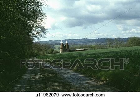 Stock Photo - Drive across fields to traditional oasthouse conversion. Fotosearch