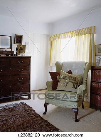 Elephant-print cushions on armchair with green loosecover in white country bedroom View Large Photo Image Stock Image - Elephant-print cushions on armchair with green loosecover in white country bedroom. Fotosearch