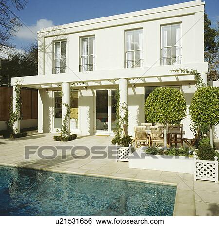 Exterior of white house with pergola in front of swimming pool View Large Photo Image Stock Photograph - Exterior of white house with pergola in front of swimming pool. Fotosearch