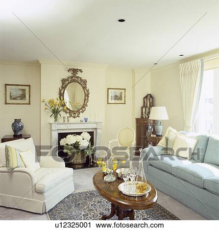 Firescreen in front of fireplace in traditional living room with pastel blue sofa and white armchair View Large Photo Image Stock Image - Firescreen in front of fireplace in traditional living room with pastel blue sofa and white armchair. Fotosearch