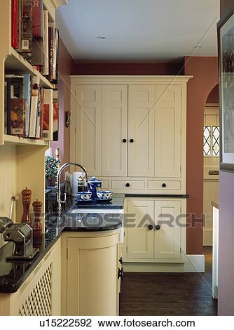 Fitted cream dresser in traditional kitchen with sideways view of sink in granite worktop View Large Photo Image Stock Image - Fitted cream dresser in traditional kitchen with sideways view of sink in granite worktop. Fotosearch