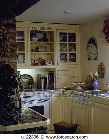 Fitted dishwasher and white oven in small yellow cottage kitchen with green tiled worktops View Large Photo Image Stock Image - Fitted dishwasher and white oven in small yellow cottage kitchen with green tiled worktops. Fotosearch