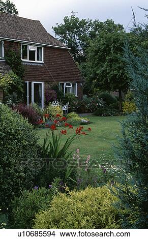 Flower borders and lawn in front of small country house in summer View Large Photo Image Picture - Flower borders and lawn in front of small country house in summer. Fotosearch