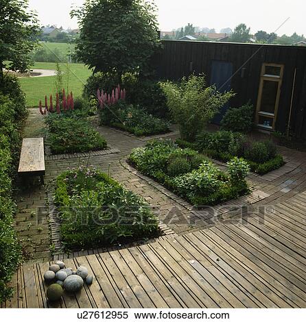 Formal beds with decking and paved paths in large country garden View Large Photo Image Stock Photography - Formal beds with decking and paved paths in large country garden. Fotosearch