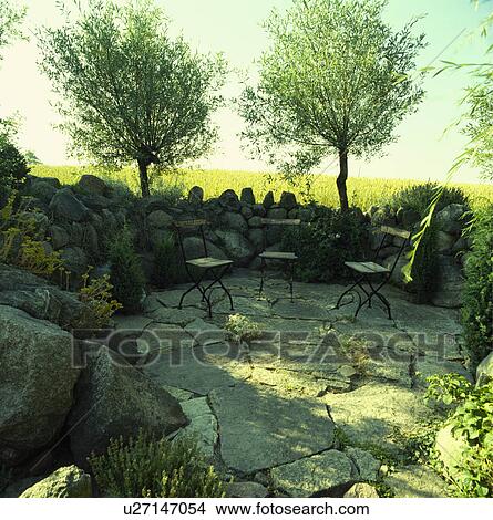 Picture - Furniture on patio in country garden in summer. Fotosearch
