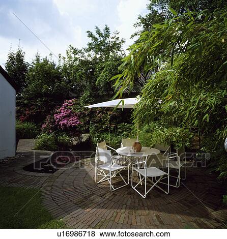 Furniture on patio in summer garden in front of country house View Large Photo Image Stock Photo - Furniture on patio in summer garden in front of country house. Fotosearch