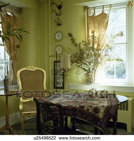 Gilt framed 18th century chair in pale green dining room with oriental rug on circular table View Large Photo Image Stock Image - Gilt framed 18th century chair in pale green dining room with oriental rug on circular table. Fotosearch