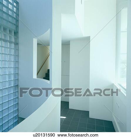 Stock Image - Glass brick wall and grey floor tiles in white architectural hall. Fotosearch