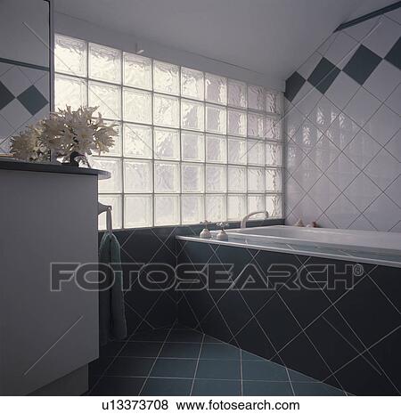 Glass brick window in modern white tiled bathroom with green tiled bath surround View Large Photo Image Stock Photo - Glass brick window in modern white tiled bathroom with green tiled bath surround. Fotosearch