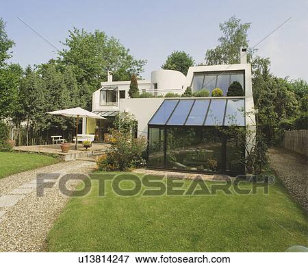 Stock Photo - Glass conservatory extension on modern white house in the country. Fotosearch