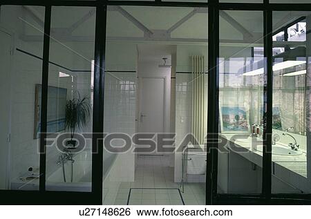 Glass doors open to modern white bathroom View Large Photo Image Stock Photograph - Glass doors open to modern white bathroom. Fotosearch